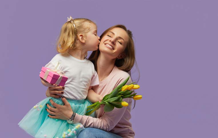 کودکی مادر خود را بغل کرده و هدیه روز مادر به او می دهد به همراه گل